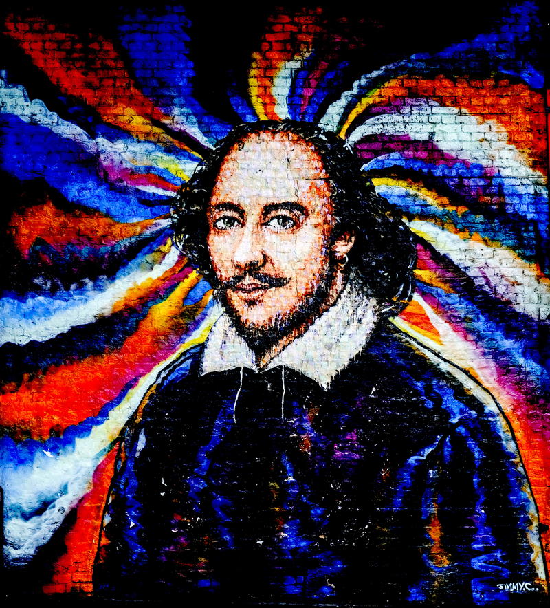 Portrait of William Shakespeare painted onto a brick wall with multi-coloured swirling background